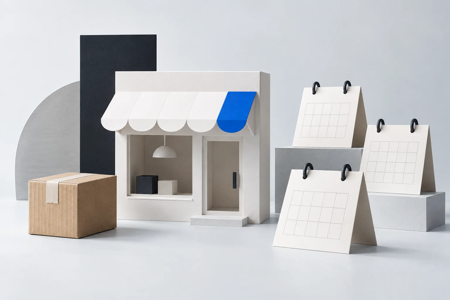 A paper storefront with a blue awning, a parcel and three blank desk calendars.